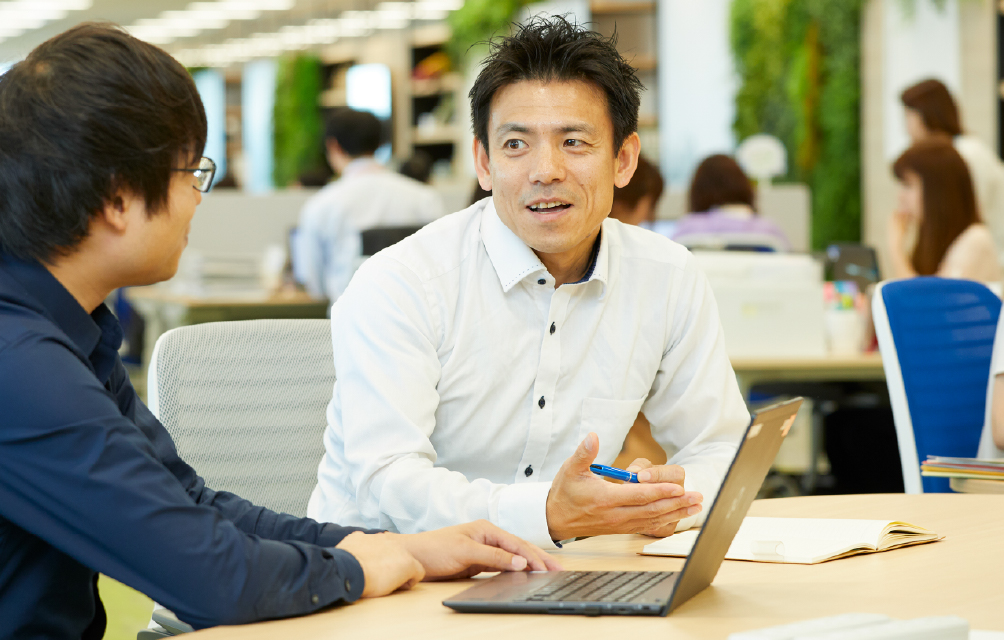 市川さんが同僚と会話している様子